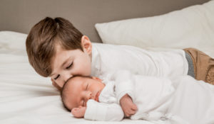 brother kissing his brother at their newborn session by Alexandra Szebenyik photography